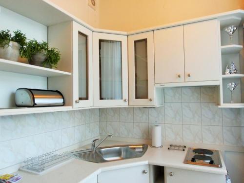 a kitchen with white cabinets and a sink at Hotel BAST Wellness & SPA in Inowrocław