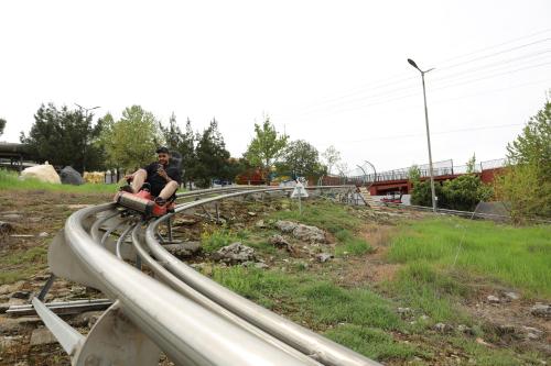 a man riding a toy train on the tracks at Shingelbana Resort in Rawandoz