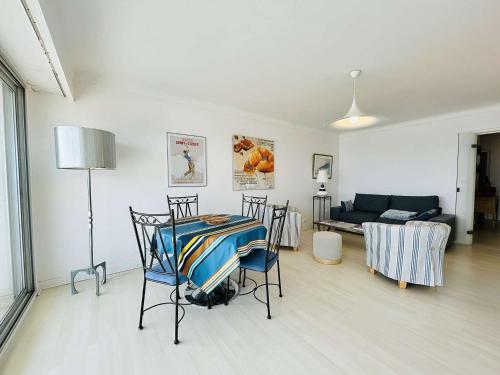 un salon avec une table, des chaises et un canapé dans l'établissement Appartement 2 pièces face mer avec terrasse et parking privatif - La Baule - FR-1-245-151, à La Baule