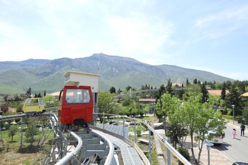 a red train on a track with mountains in the background at Shingelbana Resort in Rawandoz