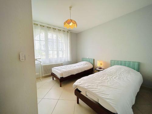 une chambre avec deux lits et une fenêtre dans l'établissement Séjour enchanteur à Pornichet : Maison 3 pièces, 6 couchages, proche plage avec jardin et terrasse sud - FR-1-245-155, à Pornichet