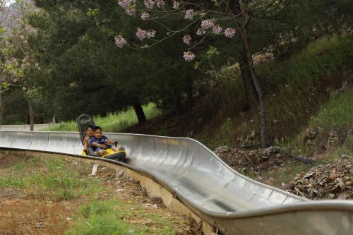 two children riding on a roller coaster on a slide at Shingelbana Resort in Rawandoz