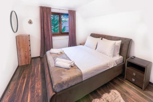 a bedroom with a bed with two towels on it at Cedrus Bran Boutique in Bran