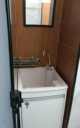 a bathroom with a white sink and a mirror at Apartamento Studio no centro de São Lourenço in São Lourenço