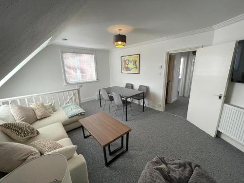 a living room with a couch and a table at Town Centre Apartment in Eastbourne
