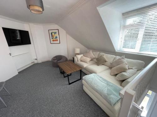 a living room with a couch and a table at Town Centre Apartment in Eastbourne