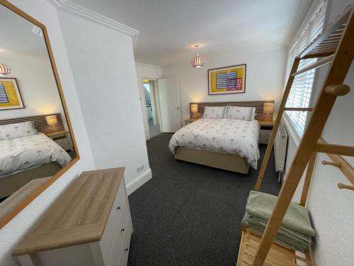 a bedroom with two beds and a mirror at Town Centre Apartment in Eastbourne