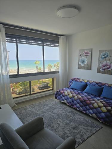 a living room with a couch and a view of the ocean at GK apartment Beauty in Bat Yam