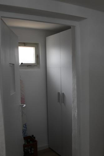 a white cabinet in a room with a window at s'Lena Häusle in Dormettingen