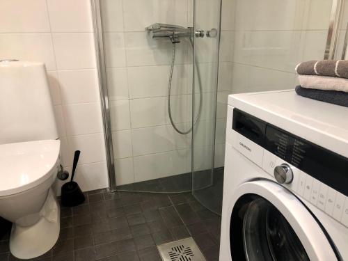 y baño con ducha y lavadora. en Scandinavian Home in Heard City, en Helsinki