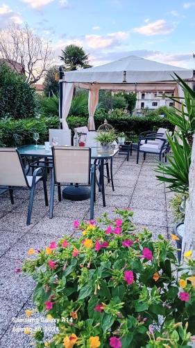 a patio with a table and chairs and flowers at Casa Germana in Invorio Inferiore