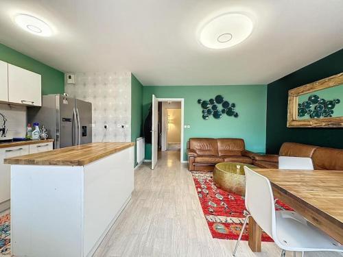 une cuisine et un salon avec une table et un canapé dans l'établissement Charmante maison familiale, à Vezin-le-Coquet