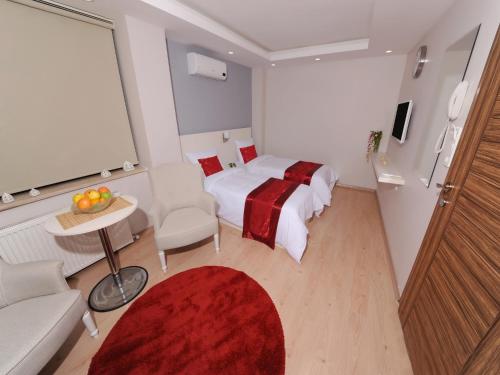 um quarto de hotel com uma cama e um tapete vermelho em Gazel Suites Downtown em Istambul