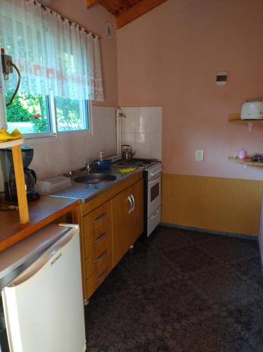 a kitchen with a sink and a stove top oven at Cabañas La Perla in Golondrinas