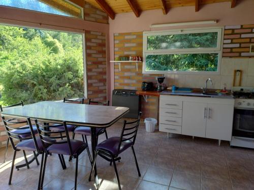 a kitchen with a table and chairs and a sink at Cabañas La Perla in Golondrinas