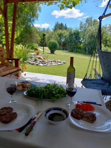 a table with plates of food and a bottle of wine at Cabañas La Perla in Golondrinas