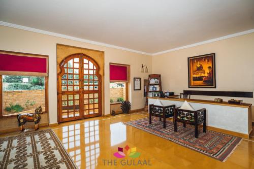 a living room with two chairs and an open door at The Gulaal in Jaisalmer