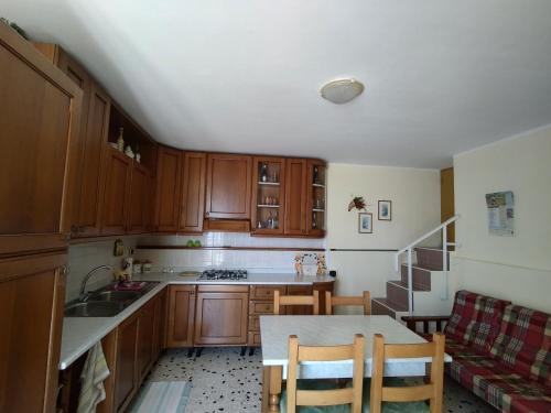 a kitchen with wooden cabinets and a table with chairs at Camere "Riviera di Ulisse" in Minturno