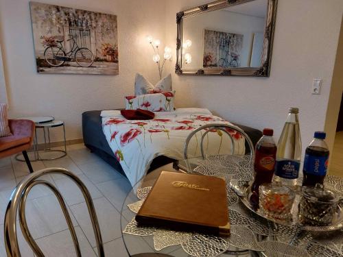 a room with a bed with a table and a mirror at Ferienwohnung Pension Waldblick in Heidenheim