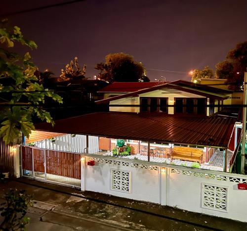 a house with a white fence at night at Ken Homestay in Ban Hua Takhe