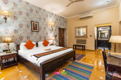 a bedroom with a bed and a desk at The Gulaal in Jaisalmer
