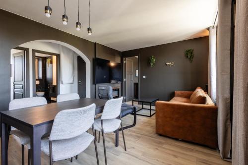 un salon avec une table, des chaises et un canapé dans l'établissement Votre expérience cinéma - Parenthèse nocturne, à Belfort