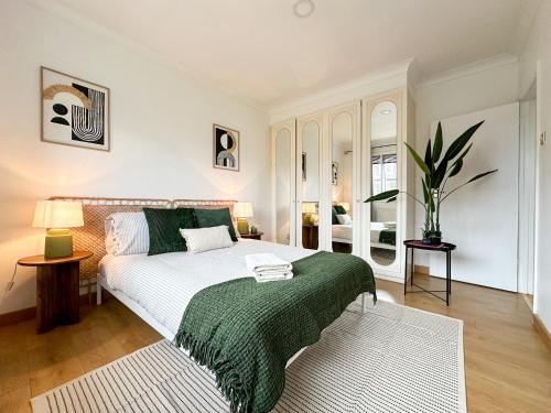 a bedroom with a bed with a green blanket at Willow Stream House - Spacious City Centre Riverside Home - FREE 2 Car Parking in Canterbury