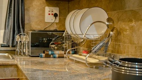 a kitchen counter with a dish drying rack on it at Joshean Apartments in Wakiso