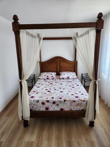 une chambre avec un lit à baldaquin dans l'établissement Charmant maison à Béziers, à Fresnes-au-Mont