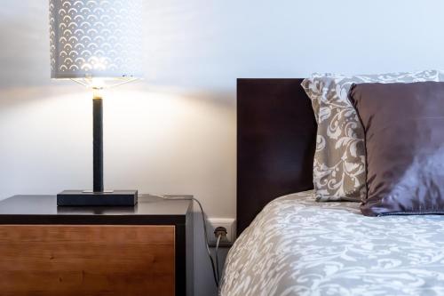a bedroom with a bed with a lamp on a night stand at Quinta da Bela Vista - Ericeira in Galiza