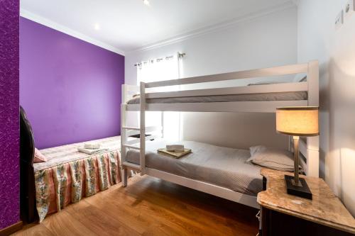 a bedroom with two bunk beds and a purple wall at Quinta da Bela Vista - Ericeira in Galiza