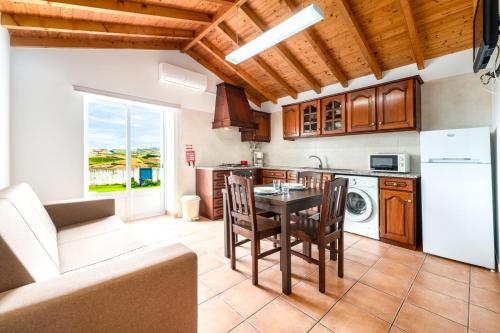 a kitchen with a table and a kitchen with a stove at Quinta da Bela Vista - Ericeira in Galiza
