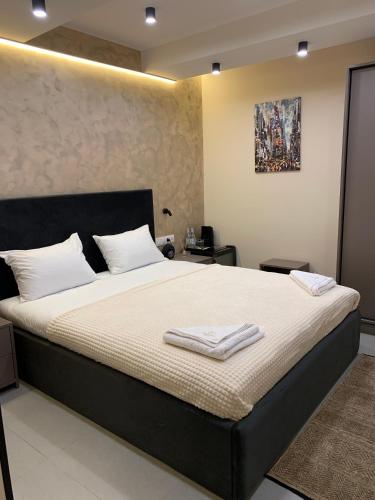 a bedroom with a large bed with two towels on it at Avenue 23 Boutique Hotel in Yerevan