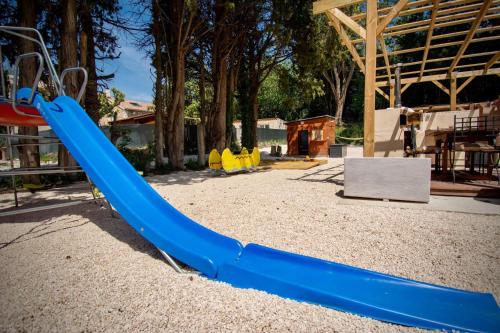 une aire de jeux avec un toboggan bleu dans un parc dans l'établissement Appartement charmant près du centre d'Avignon, 60m², piscine, à Avignon