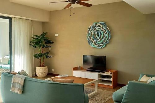 a living room with a couch and a flat screen tv at Luxury 3 Bedroom Apartment Sea View Azuri Estate in Roches Noires