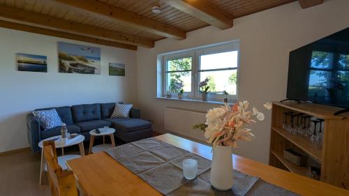 a living room with a table and a blue couch at Ferienwohnung Sonja in Westerende