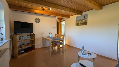 a living room with a television and a table and chairs at Ferienwohnung Sonja in Westerende