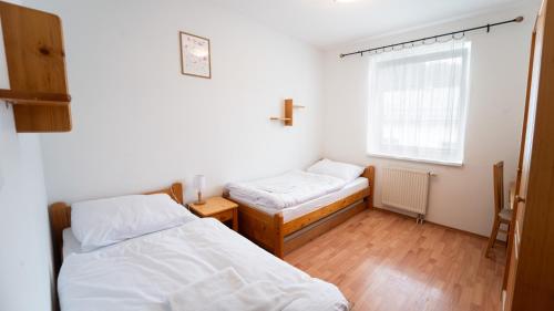 a bedroom with two beds and a window at Na Orave dobre na Orave PENZIÓN SEVERKA! in Oravská Lesná