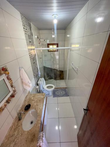 a bathroom with a shower and a toilet and a sink at Bela Vista Flats in Arraial do Cabo