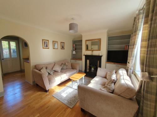 a living room with two couches and a fireplace at Cosy 2 bed cottage in Stamford in Stamford