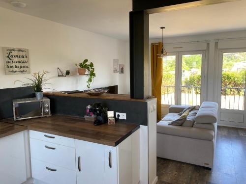 une cuisine et un salon avec un canapé dans l'établissement Charmante maison au cœur de la Drôme, à Beaumont-Monteux