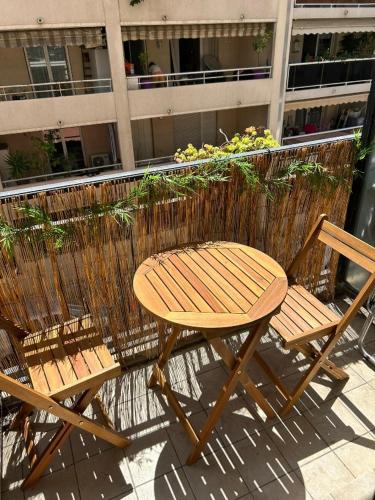 une table en bois et deux chaises à côté d'un bâtiment dans l'établissement Tournesol de Nice, à Nice