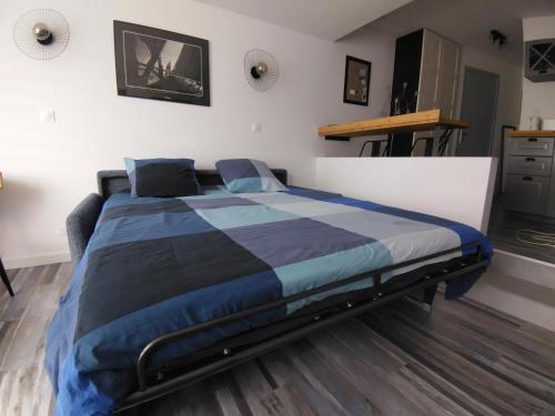 - une chambre avec un lit doté d'une couette bleue et noire dans l'établissement Studio Deauville-Les Marinas,vue mer et bassin, à Deauville