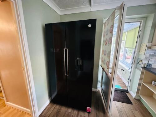 a black refrigerator in a room with a doorway at Contractors families free parking Ramsey Road in St Ives