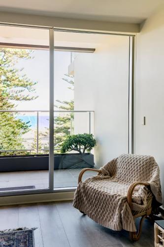 a bedroom with a bed and a large window at SUNSET GETAWAY GLENELG in Glenelg