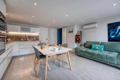 une cuisine et un salon avec une table et un canapé dans l'établissement L'Atelier 24 - Climatisation - Centre Ville, à Grenoble