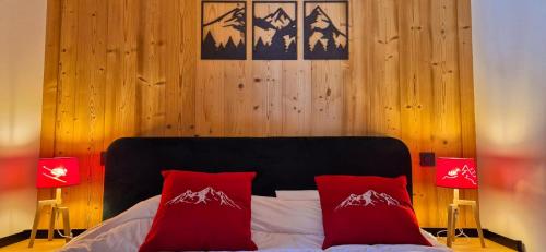 a bedroom with a bed with two red pillows at Appartement cosy - proche des pistes in La Chapelle-dʼAbondance