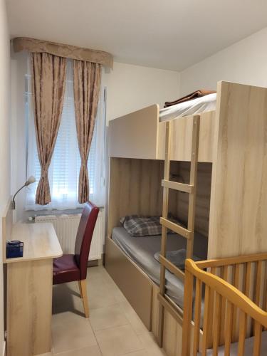 a room with a bunk bed and a desk and a chair at Dule Lux in Jagodina