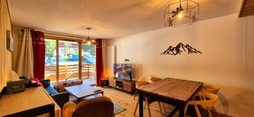 a living room with a table and a dining room at Appartement cosy - proche des pistes in La Chapelle-dʼAbondance