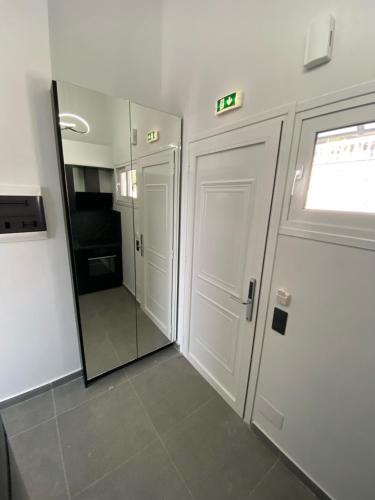 a hallway with two white doors and a mirror at Akrogiali Apartments in Barbati